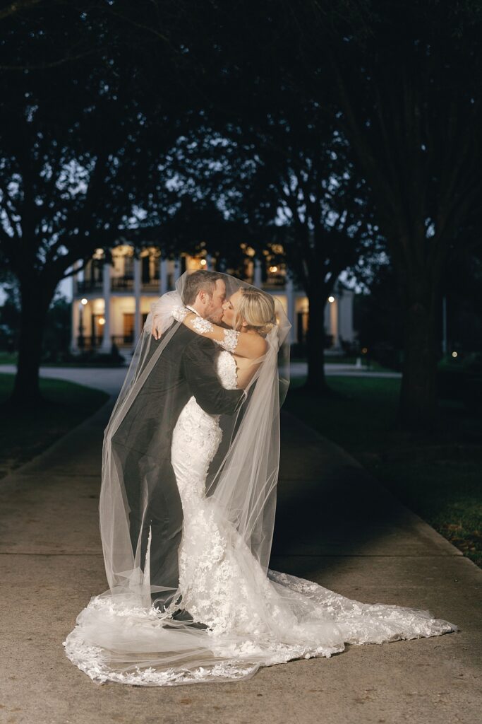bride and groom kissing outside at Sandlewood Manor