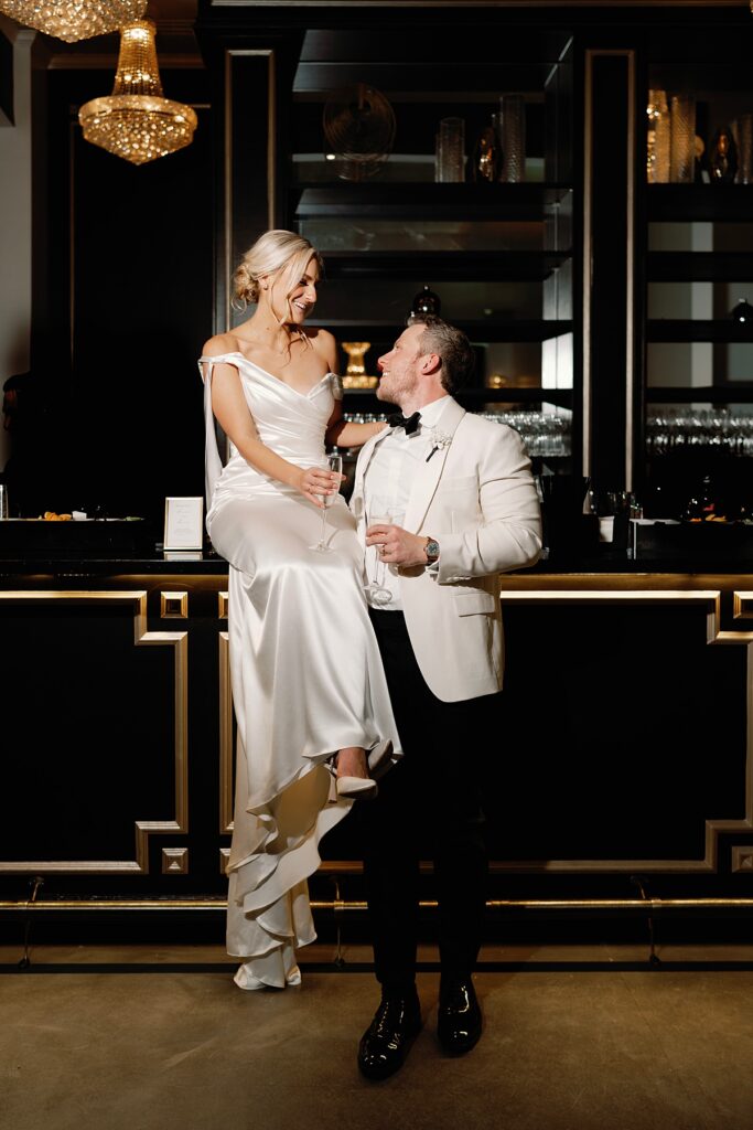 Couple on bar top at Sandlewood Manor in evening reception attire

