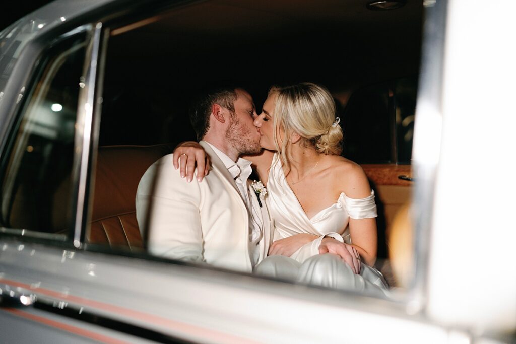 Vibrant streamer exit with vintage Rolls-Royce getaway car